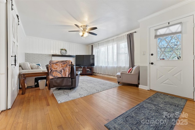 interior space with multiple windows, ornamental molding, hardwood / wood-style floors, and ceiling fan