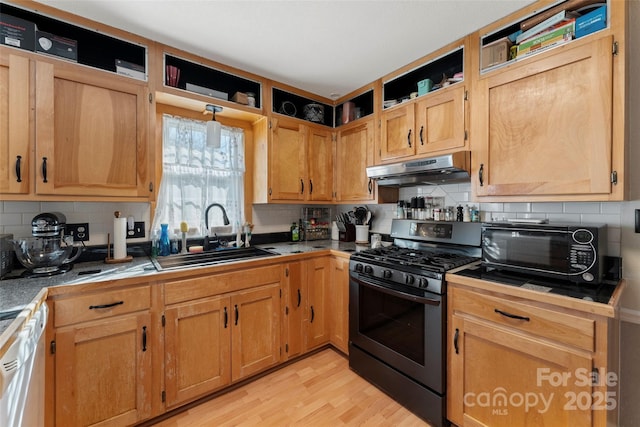 kitchen with decorative backsplash, sink, gas stove, and light wood-type flooring