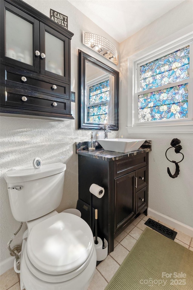 bathroom with vanity, toilet, and tile patterned floors