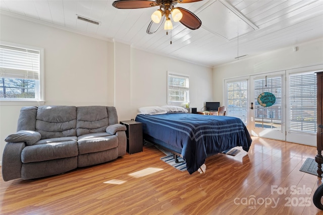 bedroom featuring ornamental molding, light wood-type flooring, access to outside, and multiple windows