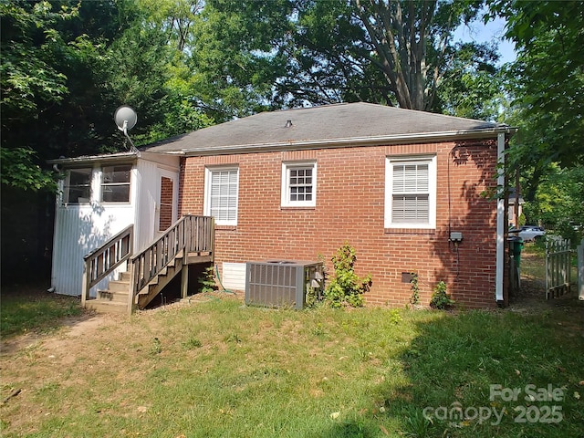 back of property with a yard and central air condition unit