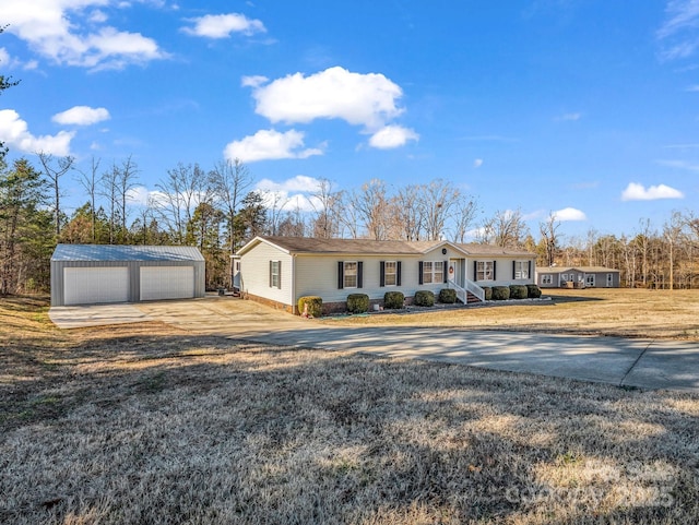 single story home featuring an outbuilding, a garage, and a front lawn