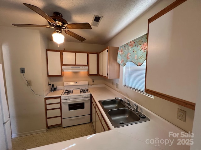 kitchen with ceiling fan, sink, a textured ceiling, and white gas range oven