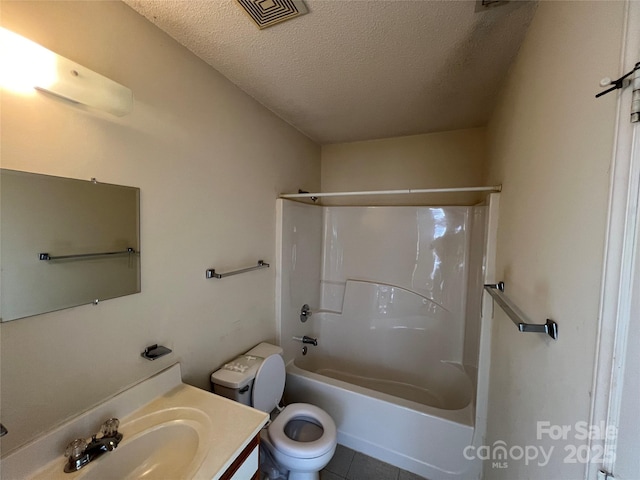 full bathroom with washtub / shower combination, tile patterned flooring, vanity, a textured ceiling, and toilet