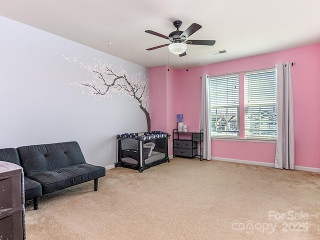 sitting room with carpet floors, baseboards, visible vents, and a ceiling fan