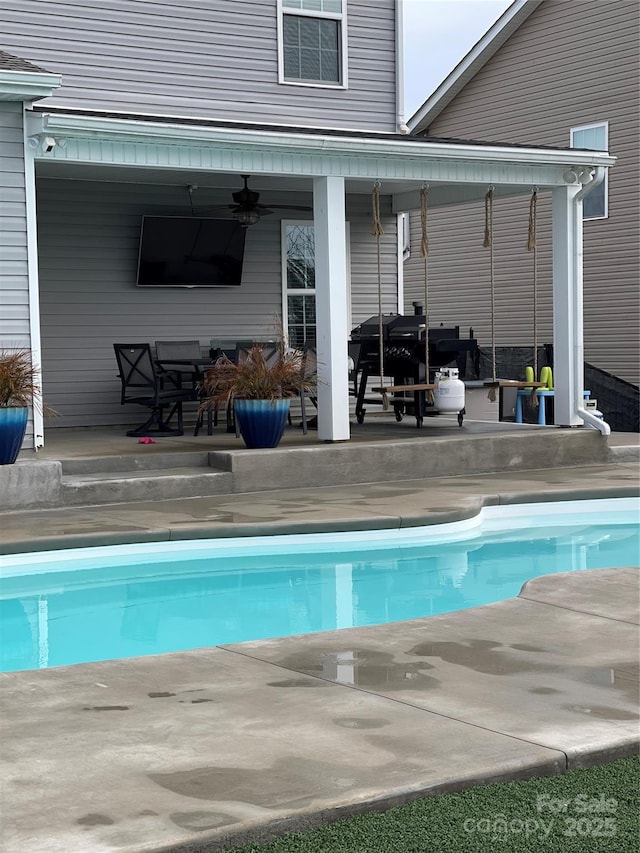 outdoor pool featuring a patio area and a ceiling fan