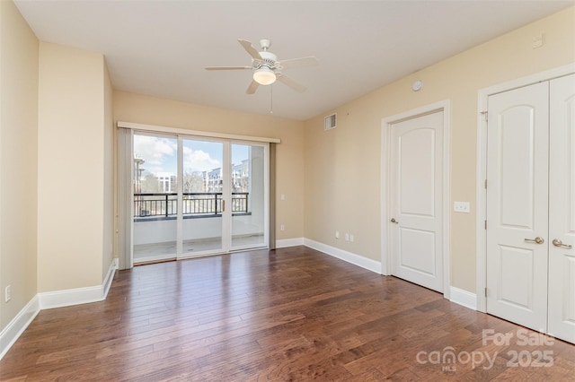 unfurnished room with ceiling fan and dark hardwood / wood-style flooring