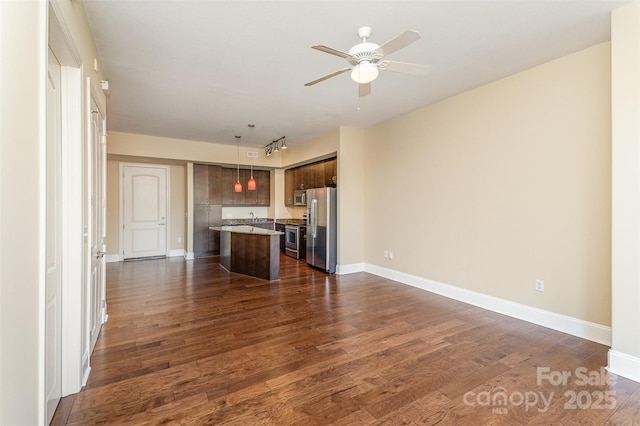 unfurnished living room with ceiling fan and dark hardwood / wood-style floors