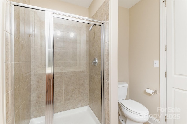 bathroom with toilet and a shower with shower door