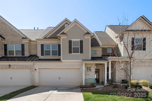 multi unit property with a standing seam roof, concrete driveway, an attached garage, and brick siding