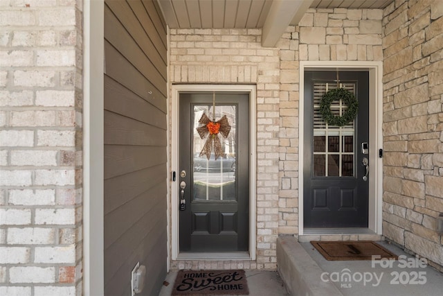 entrance to property featuring brick siding