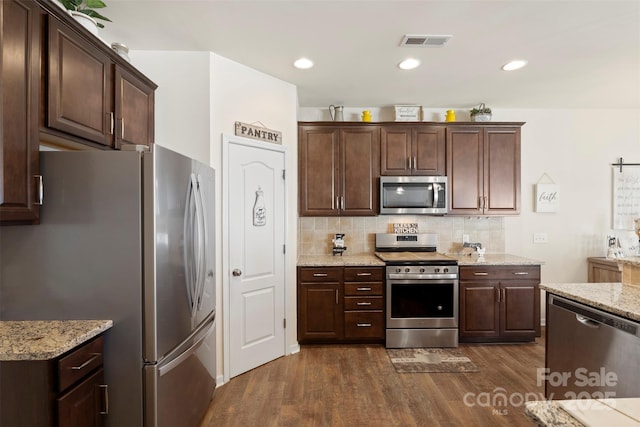 kitchen featuring visible vents, appliances with stainless steel finishes, dark wood-style flooring, and decorative backsplash