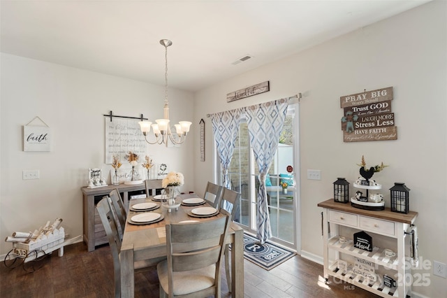 dining area featuring visible vents, baseboards, wood finished floors, and a chandelier