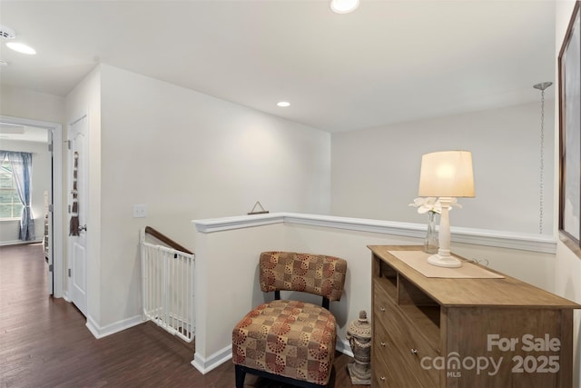 sitting room with dark wood-type flooring, recessed lighting, an upstairs landing, and baseboards