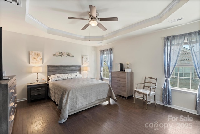 bedroom with visible vents, a raised ceiling, dark wood-style flooring, and crown molding