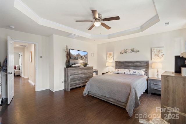 bedroom featuring visible vents, ornamental molding, a tray ceiling, and wood finished floors