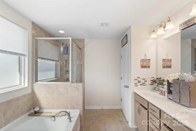 full bath with visible vents, a shower stall, double vanity, a bath, and a sink