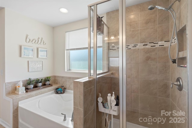 bathroom featuring a shower stall and a bath