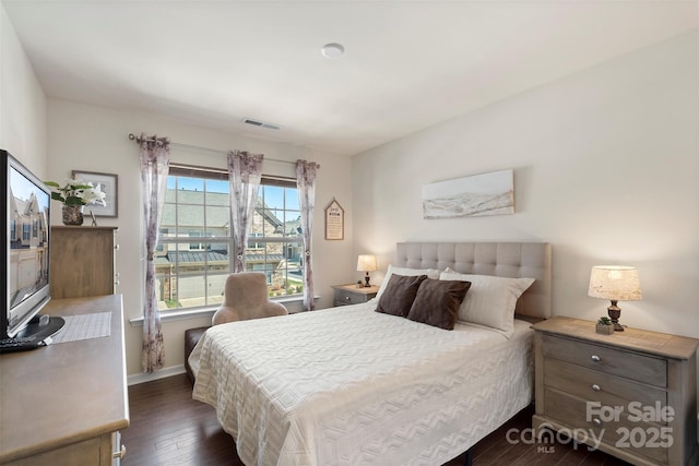 bedroom featuring visible vents, baseboards, and dark wood finished floors