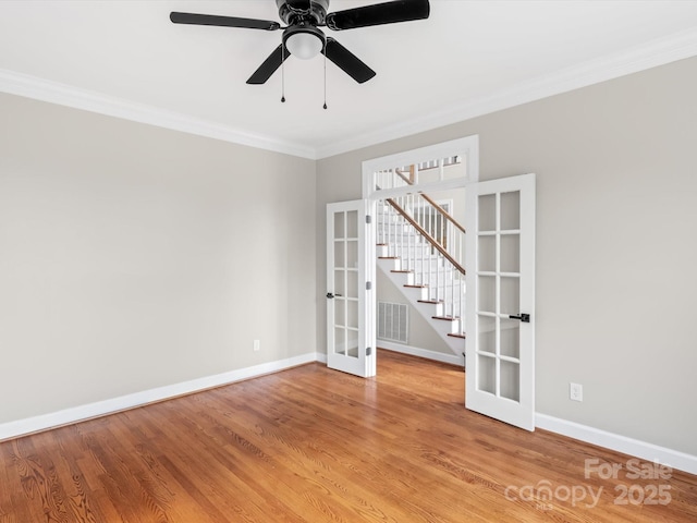 spare room with light wood finished floors, crown molding, and french doors