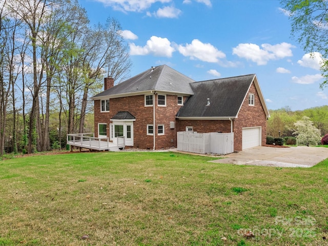 back of house with a lawn, concrete driveway, a chimney, an attached garage, and brick siding