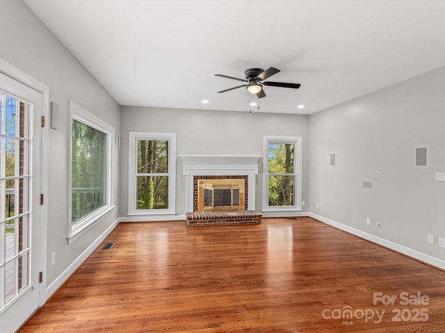 unfurnished living room with a fireplace, recessed lighting, light wood-style floors, ceiling fan, and baseboards