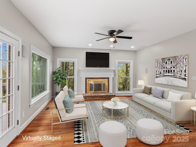 living room with baseboards, a ceiling fan, wood finished floors, a fireplace, and recessed lighting