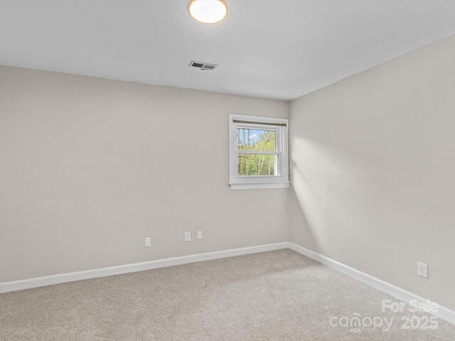 carpeted empty room featuring visible vents and baseboards