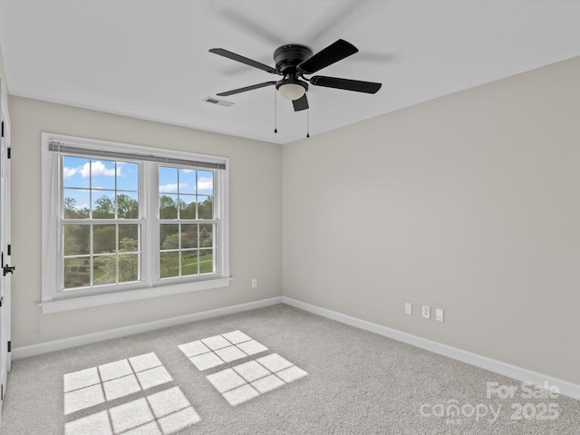 spare room featuring a ceiling fan, visible vents, light carpet, and baseboards