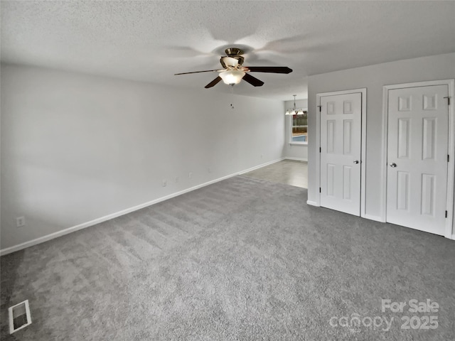 interior space featuring ceiling fan with notable chandelier and a textured ceiling