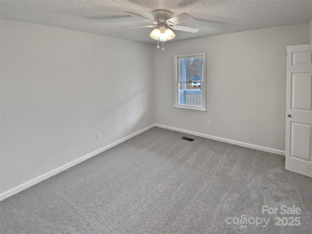 unfurnished room with ceiling fan, a textured ceiling, and carpet