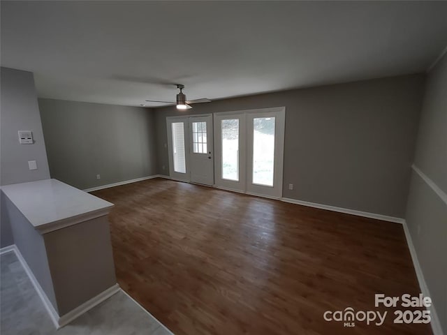 empty room featuring dark wood-type flooring and ceiling fan