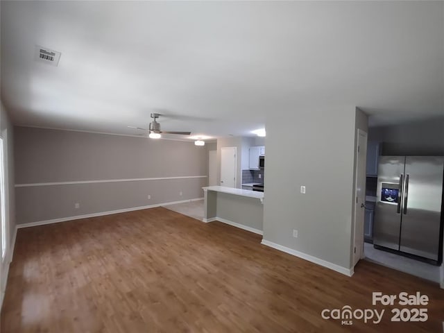 unfurnished living room featuring wood-type flooring and ceiling fan