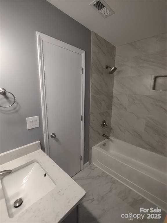 bathroom with vanity and tiled shower / bath combo