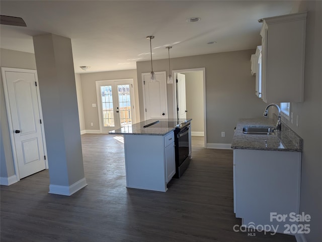 kitchen with a center island, decorative light fixtures, white cabinetry, a sink, and range with electric cooktop