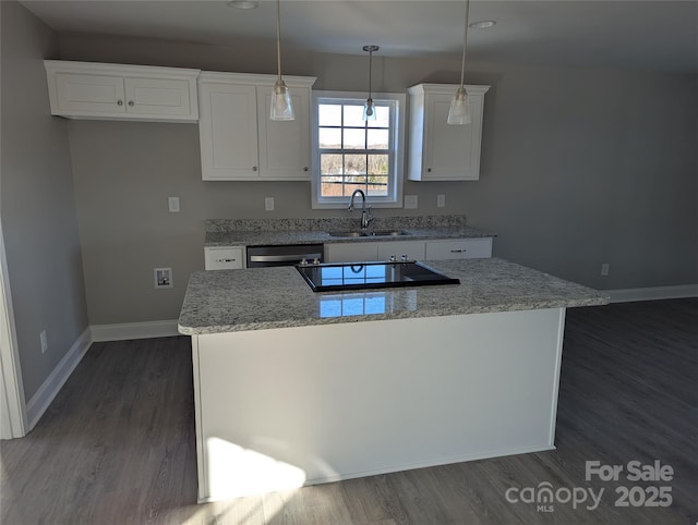 kitchen featuring a kitchen island, white cabinetry, a sink, and hanging light fixtures