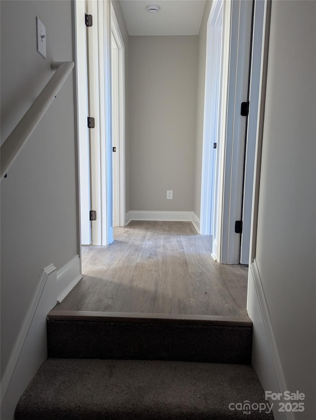 staircase with wood finished floors and baseboards