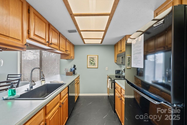 kitchen with baseboards, visible vents, light countertops, black appliances, and a sink