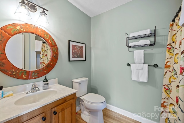 full bathroom featuring wood finished floors, vanity, toilet, and baseboards