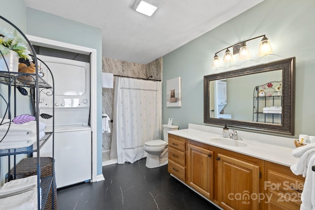 full bath featuring stacked washer / dryer, toilet, curtained shower, a textured ceiling, and vanity