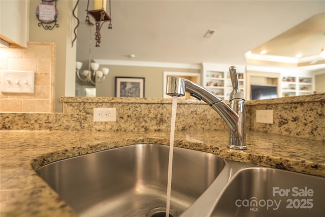 room details with backsplash, sink, and stone counters