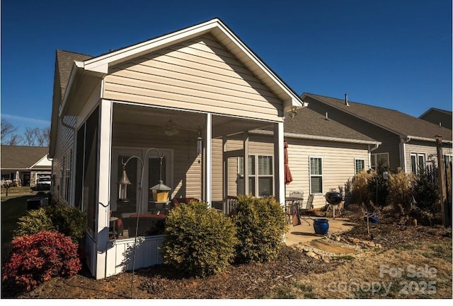 back of house with a sunroom and a patio