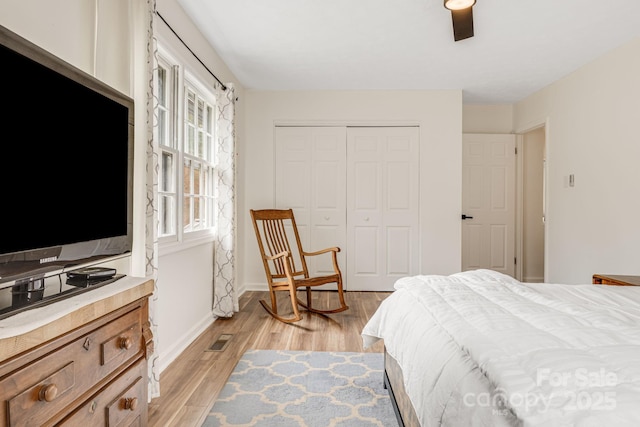 bedroom with ceiling fan, a closet, and light hardwood / wood-style flooring