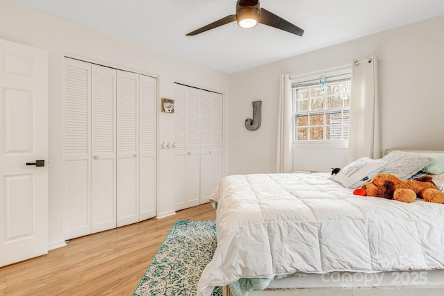 bedroom featuring multiple closets, ceiling fan, and light hardwood / wood-style floors