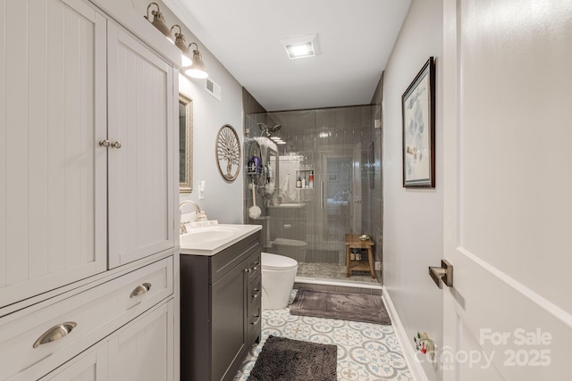 bathroom featuring an enclosed shower, vanity, tile patterned floors, and toilet