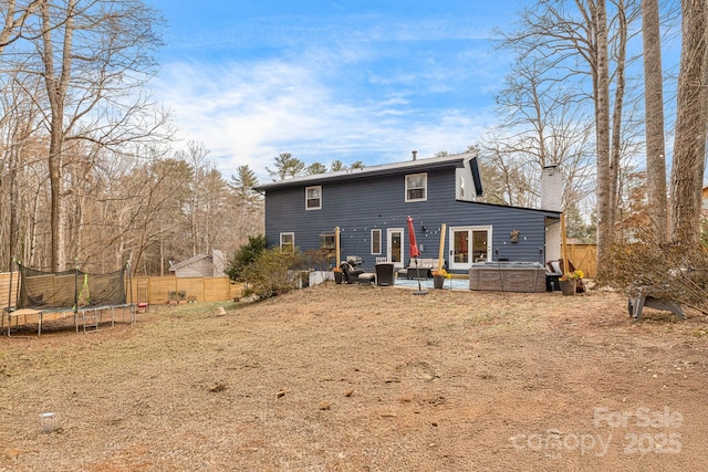 rear view of house featuring a trampoline and a patio area