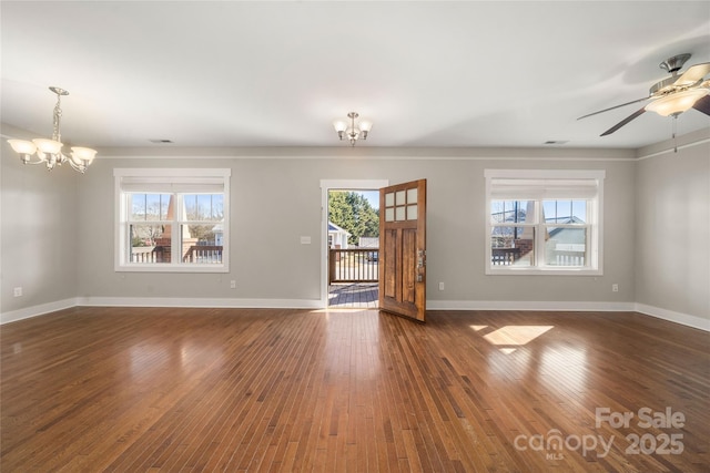 empty room featuring dark wood-type flooring and ceiling fan with notable chandelier