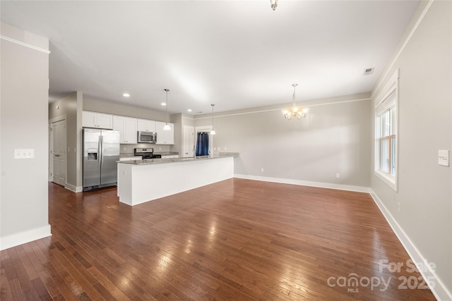 unfurnished living room with an inviting chandelier and dark wood-type flooring