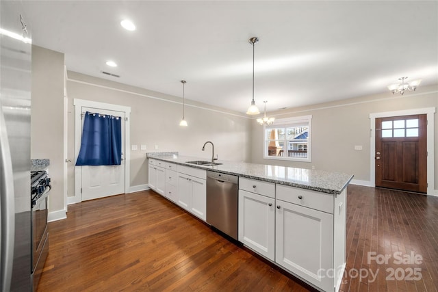 kitchen with pendant lighting, white cabinetry, kitchen peninsula, stainless steel appliances, and light stone countertops