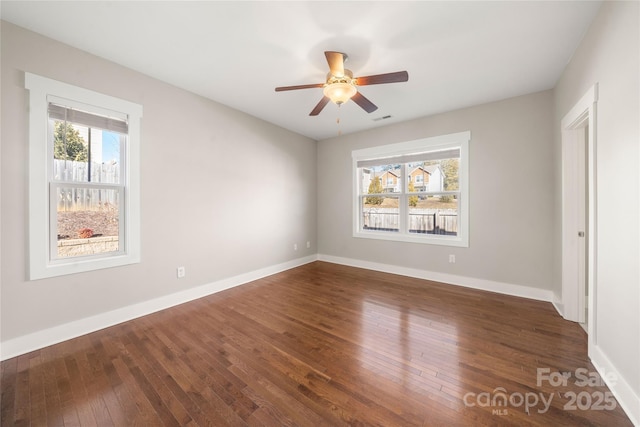 unfurnished room featuring dark wood-type flooring and ceiling fan